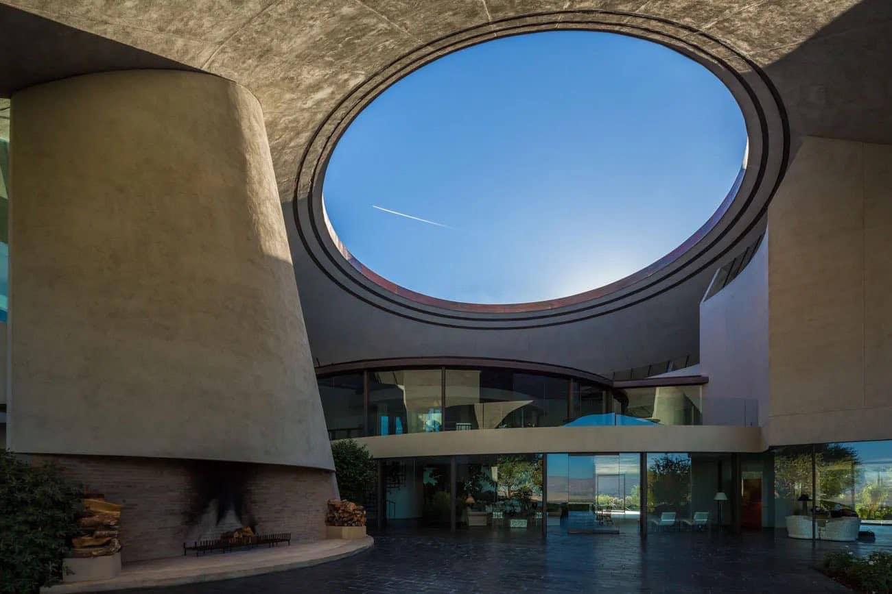 A concrete building with a large circular oculus cut through its face