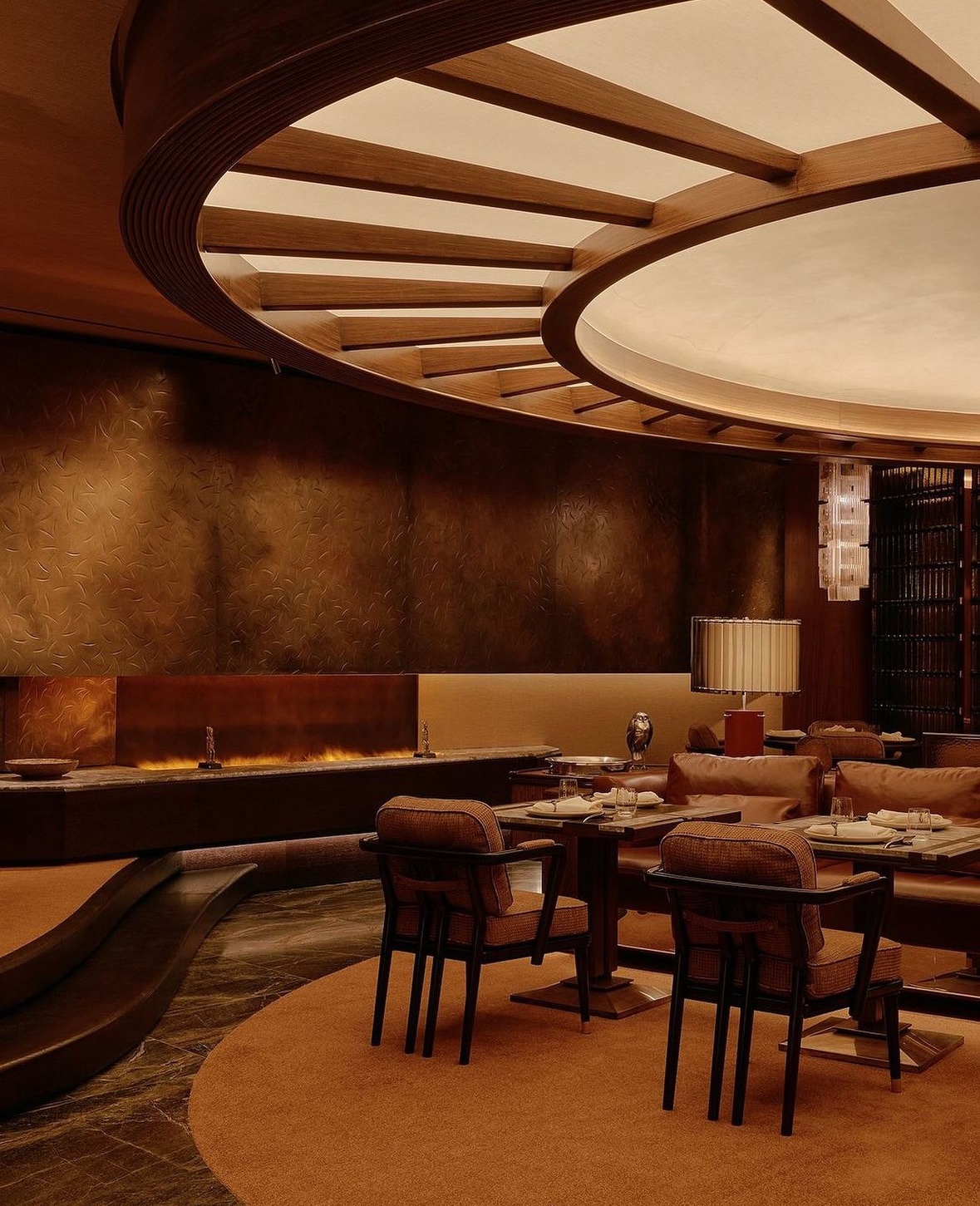 A curved, carpeted restaurant interior seen from the balcony above